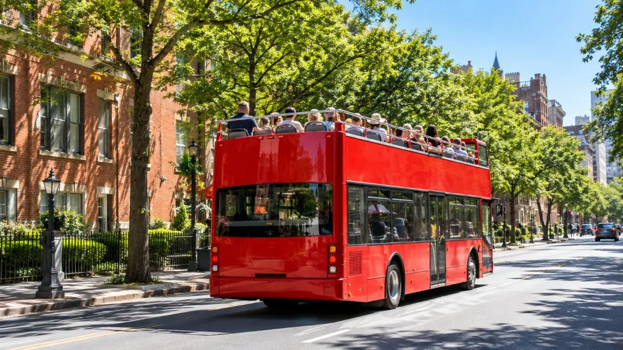 A red open-top double-decker sightseeing bus on a sunny city street