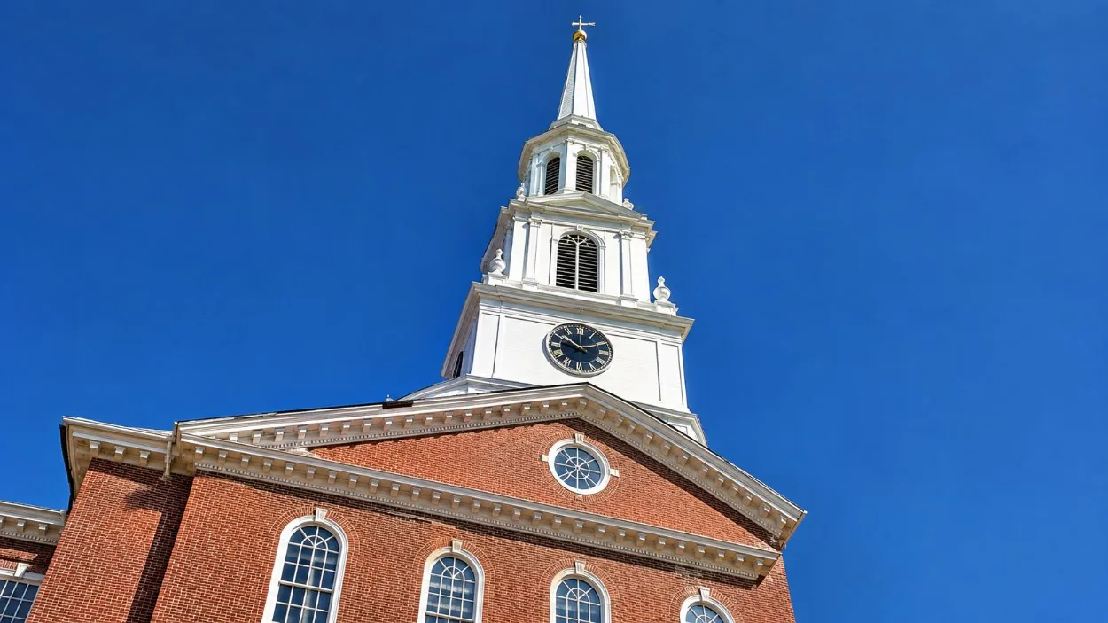 The white clock tower and steeple of Independence Hall against a blue sky